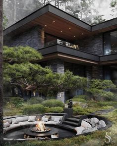 an outdoor fire pit in front of a modern house with trees and bushes around it