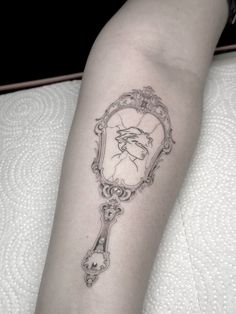 a woman's arm with a clock tattoo on the left side of her leg