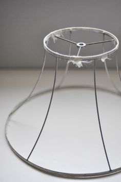 a glass table with a metal frame and white feathers on it