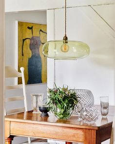 a dining room table with chairs and a potted plant on top of the table