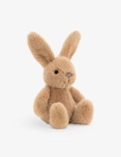 a brown stuffed rabbit sitting up against a white background