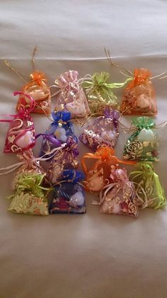 small bags filled with assorted candy sitting on top of a bed