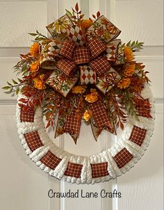 a wreath made out of brown and white crochet with orange flowers on it