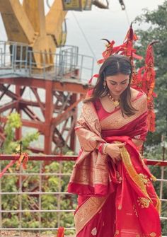 a woman wearing a red and gold sari