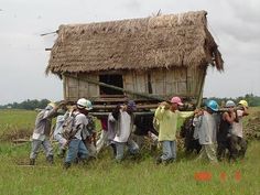 a group of people standing in front of a hut