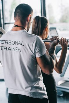 a man and woman are exercising in the gym with personal trainer t - shirt on