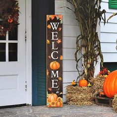 a welcome sign and hay bales with pumpkins