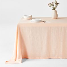 a table topped with two plates and a vase filled with flowers