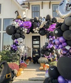 an entrance to a house decorated for halloween with balloons and decorations in the shape of skeletons