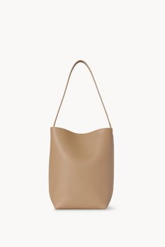 Classic tote bag in soft milled calfskin leather with interior toggle closure and flat handle. 13 x 11 x 6 in. 100% Leather Made in Italy Style: W1313L83DNS Classic Tote Bag, Calf Skin, The Row, Classic Style, 404 Not Found, Not Found, Italy, Tote Bag