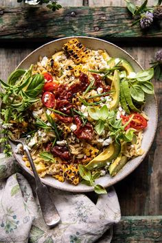 a white bowl filled with rice and veggies on top of a wooden table