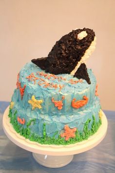 a cake decorated with an orca whale on top of a blue and white plate