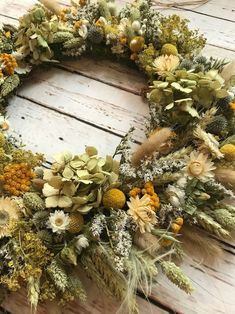 a wreath made out of dried flowers sitting on top of a wooden table