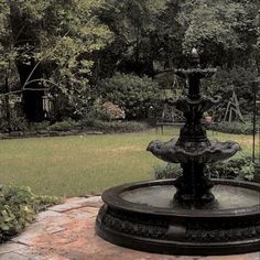 a water fountain sitting in the middle of a garden