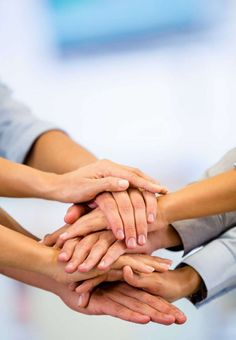 several people stacking their hands together - stock photo - images