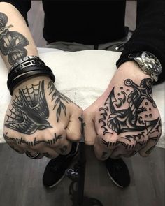 two people with tattoos on their hands holding each other