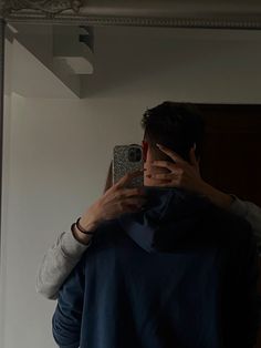 a man taking a selfie in front of a mirror with his cell phone up to his face