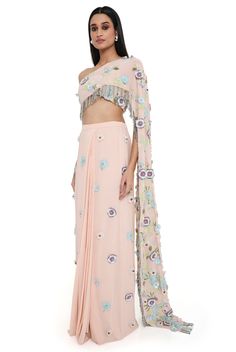 Blush pink georgette embroidered choli with attached pallu with hanging colorful tassels and embroidered pre-stitched skirt. Disclaimer: Since we are a made-to-measure brand and our dyeing process and embroidery are handcrafted, there may be slight variations in the color and embroidery of the actual product. The print placement may also vary from what is represented in the images shown on the product page. Spring Embellished Georgette Sharara, Pink Bohemian Lehenga With Sheer Dupatta, Bohemian Pink Lehenga With Sheer Dupatta, Pink Embellished Pre-draped Saree For Festivals, Traditional Pink Floral Embroidered Pre-draped Saree, Embellished Pink Pre-draped Saree For Festivals, Traditional Party Saree With Tassels, Pink Georgette Blouse With Floral Embroidery, Embroidered Floor-length Pink Pre-draped Saree