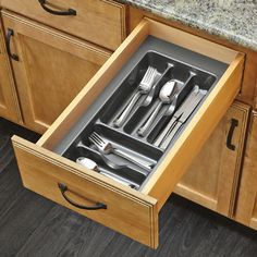 an open drawer with utensils in it