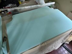 there is a blue sheet on top of the bed and some other items around it