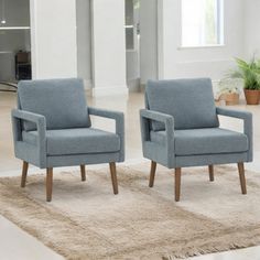 two blue chairs sitting on top of a rug