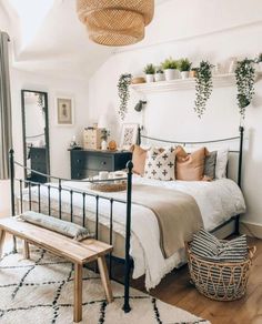 a bed room with a neatly made bed and lots of plants