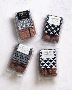 four packaged chocolates in plastic containers on a counter top, with the label choco latina next to them