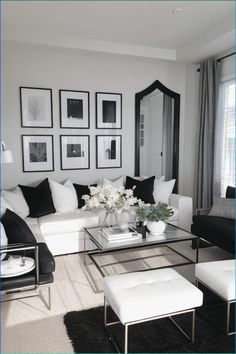 a black and white living room with pictures on the wall above the couch, coffee table