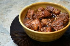 a wooden bowl filled with meat and sauce