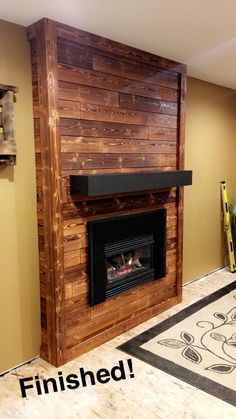 an unfinished fireplace with wood paneling on the wall