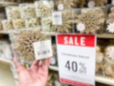 a person holding up a sale sign in front of a store display filled with cereal