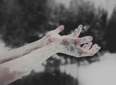 two hands reaching out to touch each other with white powder on their palms and fingers