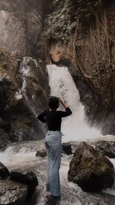 a person standing in front of a waterfall