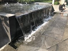 a man kneeling down next to a water fountain