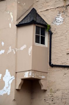 the corner of an old building with a window