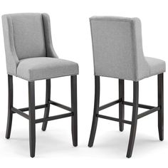 two gray upholstered barstools with buttons on the back and arms, side view