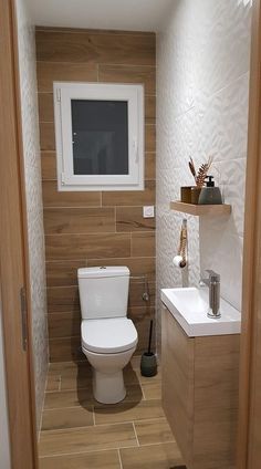 a white toilet sitting in a bathroom next to a sink