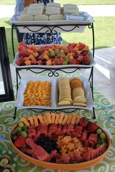 three tiered trays filled with different types of food on top of a table