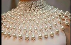 the back of a woman's dress with pearls on it