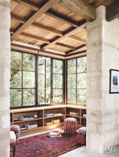 a room with large windows and a rug on the floor