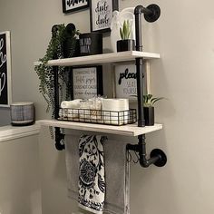 the bathroom is decorated with black and white decor, such as toilet paper towels and plants