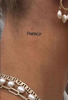 a woman's neck with the word energy written on her left side ribcage