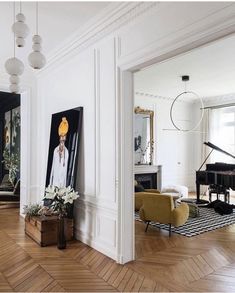 a living room filled with furniture and a painting on the wall above a grand piano