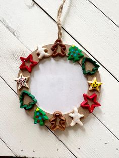 an ornament made out of clay and decorated with christmas decorations on a white wooden background