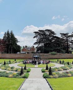 people are sitting in the middle of a formal garden