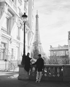 black and white photograph of two people near the eiffel tower