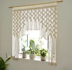 three potted plants sitting on top of a window sill in front of a curtain