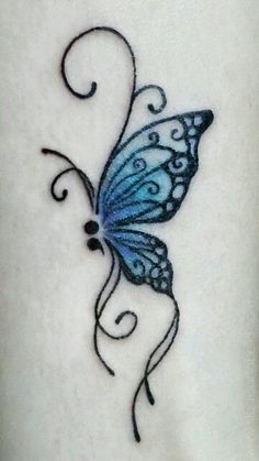 a blue butterfly tattoo on the back of a woman's leg, with swirls and