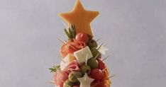 a christmas tree made out of fruits and veggies is shown in front of a gray background