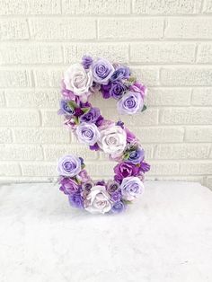 purple and white flowers arranged into the letter s